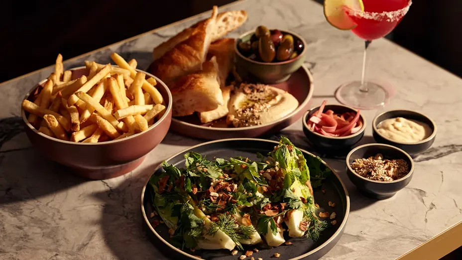 Arrangement of salad, fries, and entrees with a cocktail