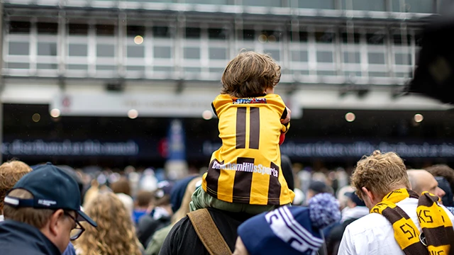 Young Hawthorn fan on shoulders outside MCG
