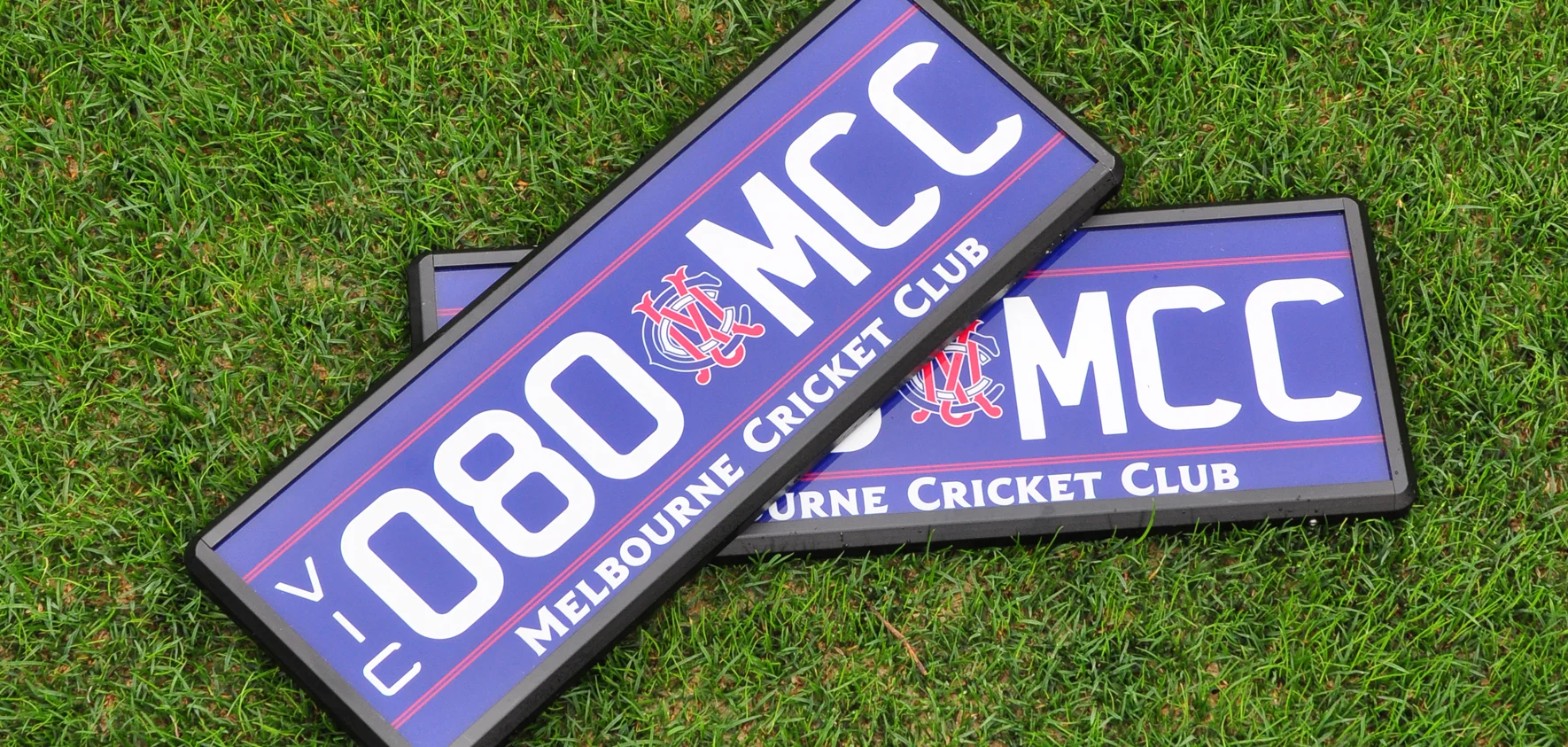 080.MCC number plate with navy background, white lettering, red detailing and logo