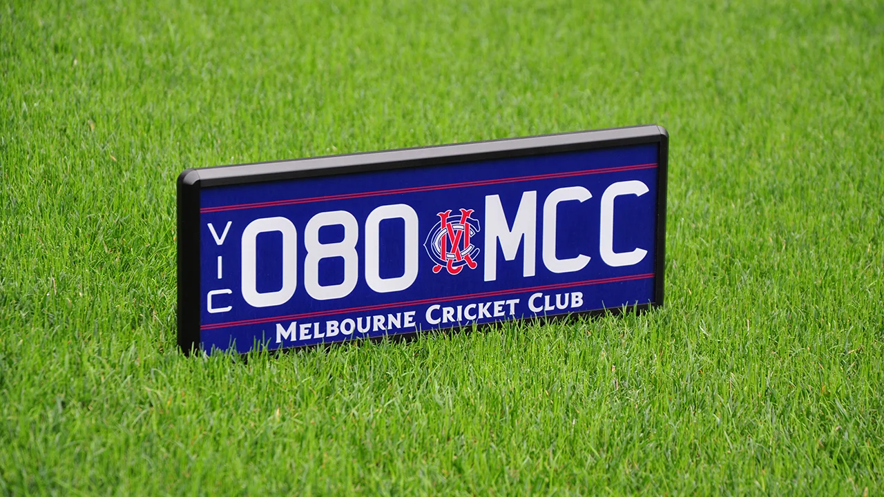 080.MCC number plate with navy background, white lettering, red detailing and logo