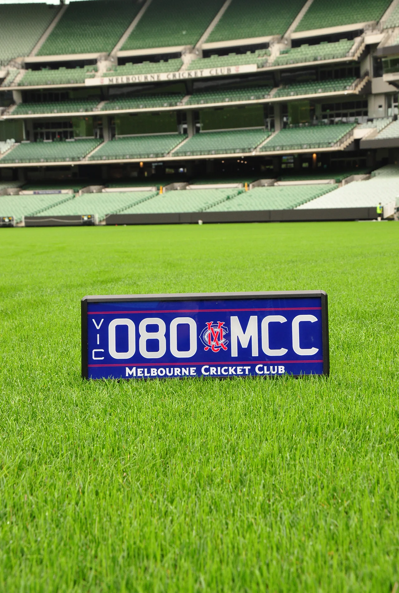 080.MCC number plate with navy background, white lettering, red detailing and logo