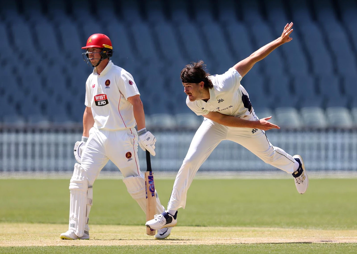 Cameron McClure bowls wearing the Victorian Country squad cricket whites