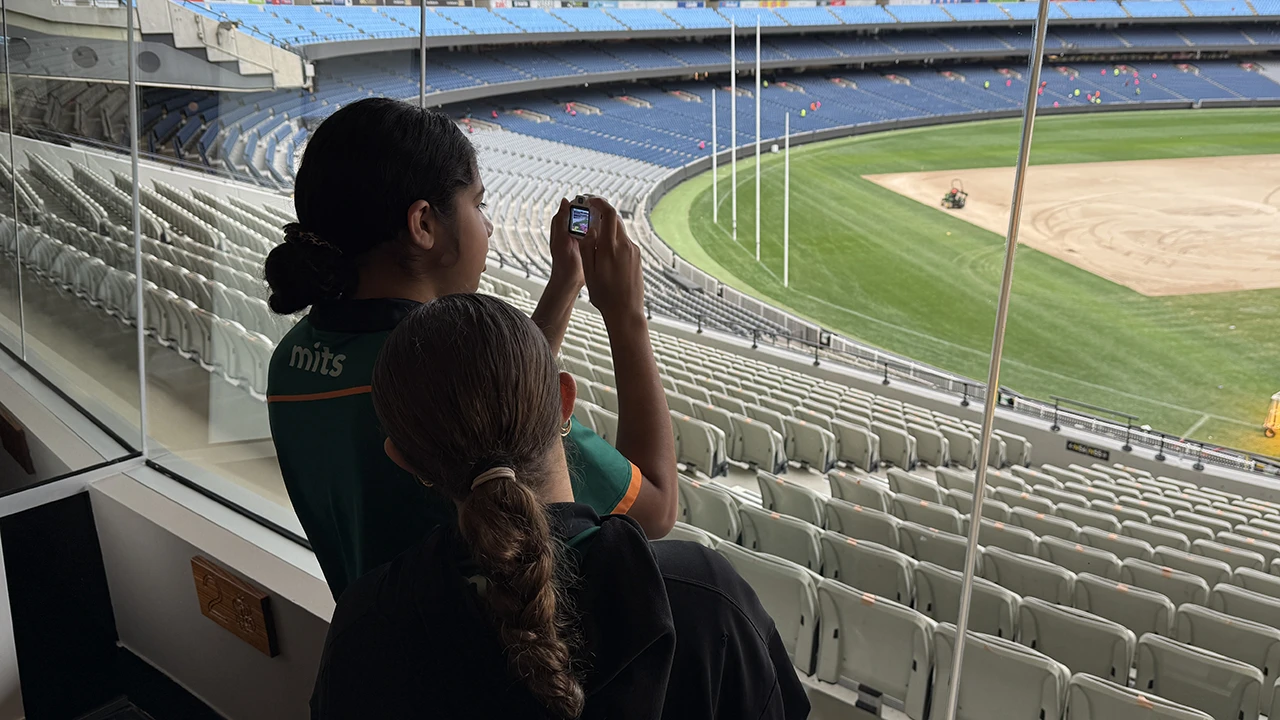 Two MITS students take a photo of the MCG turf transformation