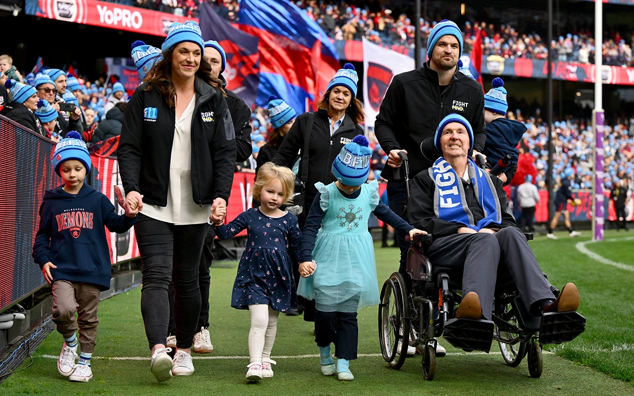 Neale Daniher, daughter Bec and family along the MCG boundary line during Big Freeze match
