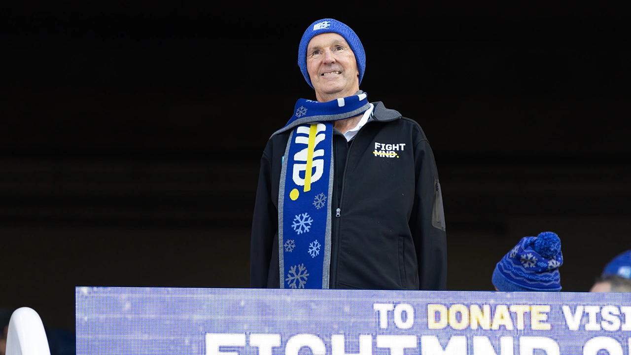 Neale Daniher smiling wearing Fight MND merch
