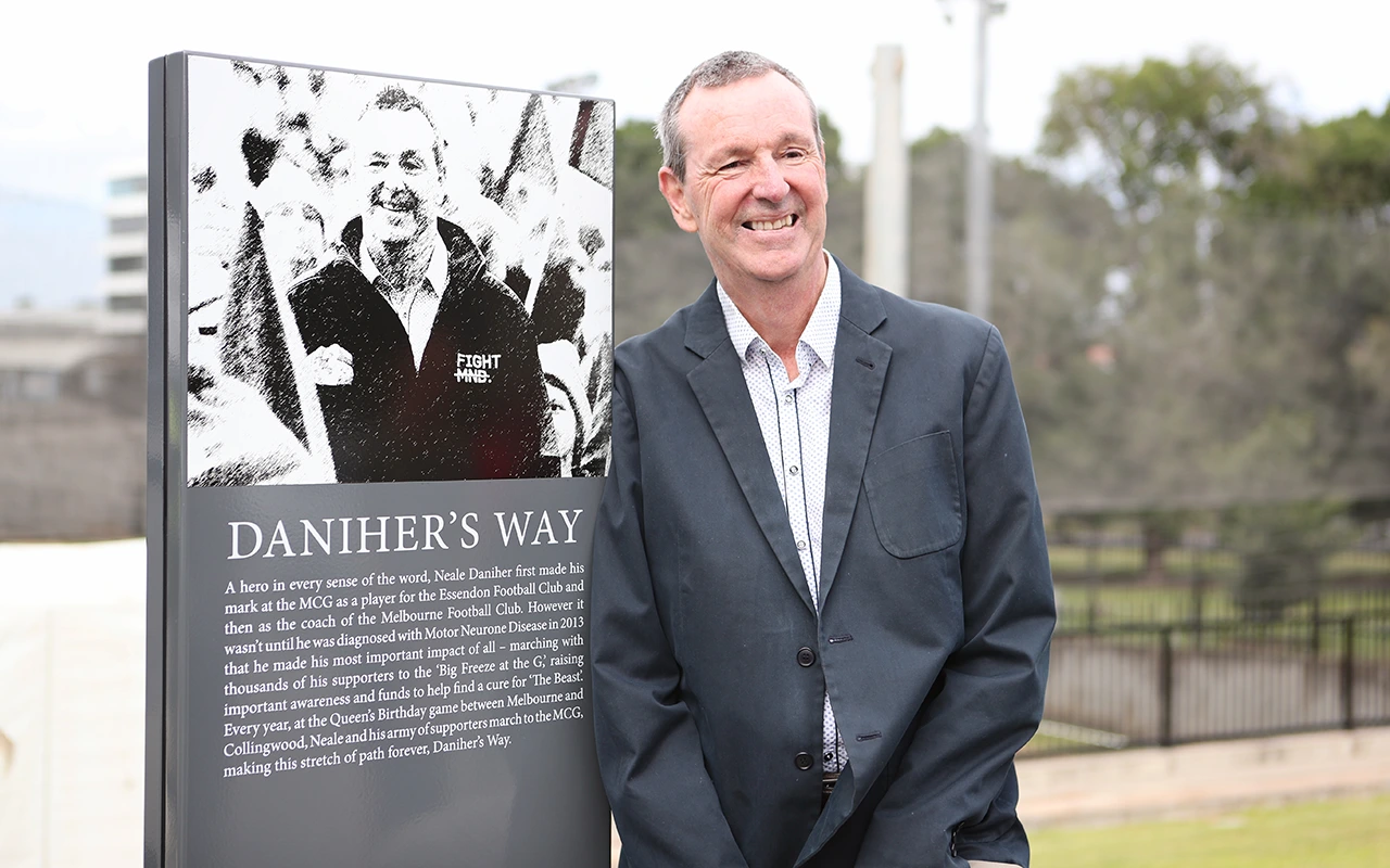 Neale Daniher next to Daniher's Way sign outside the MCG