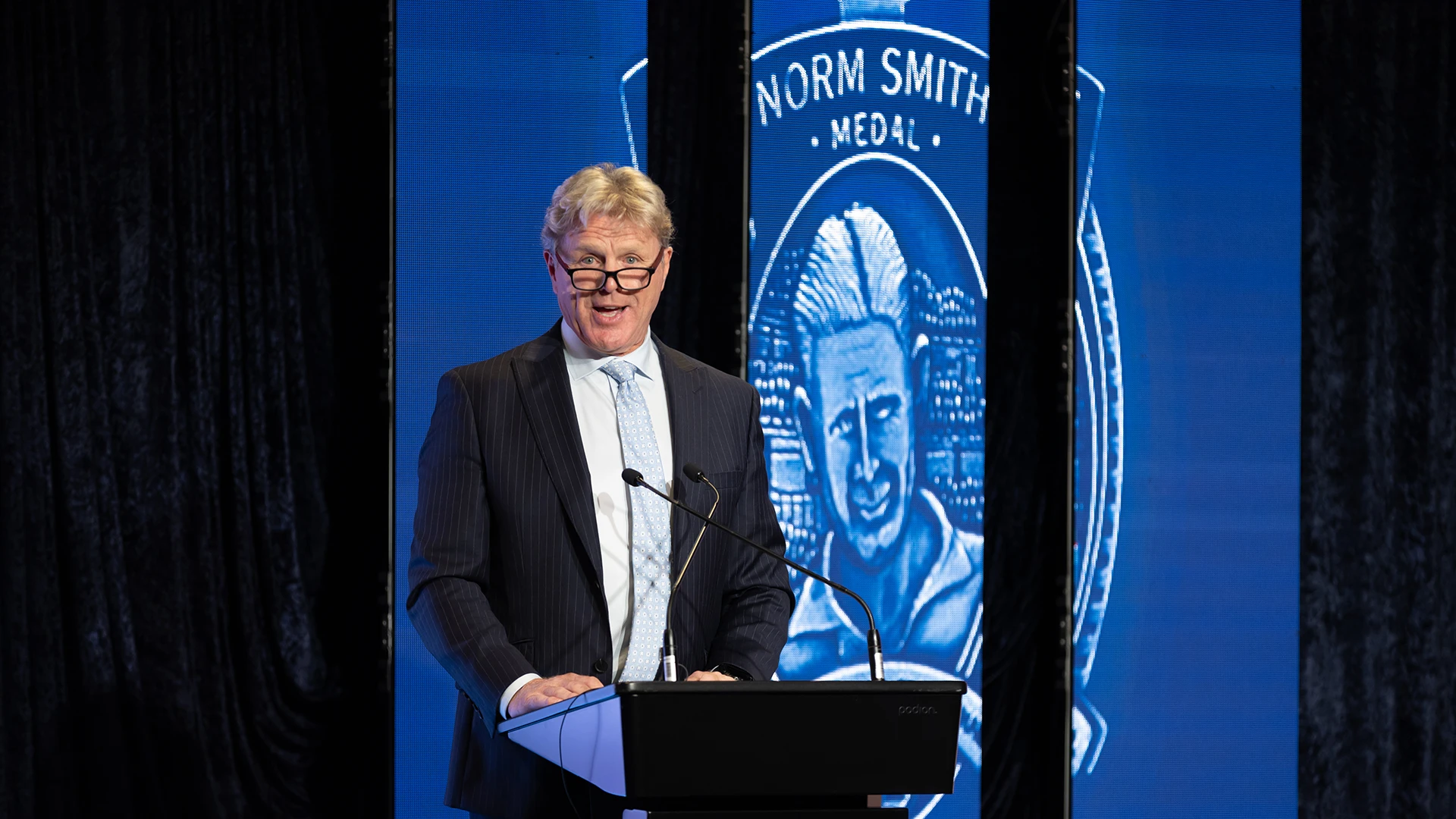 Dermott Brereton delivers Norm Smith Oration on stage