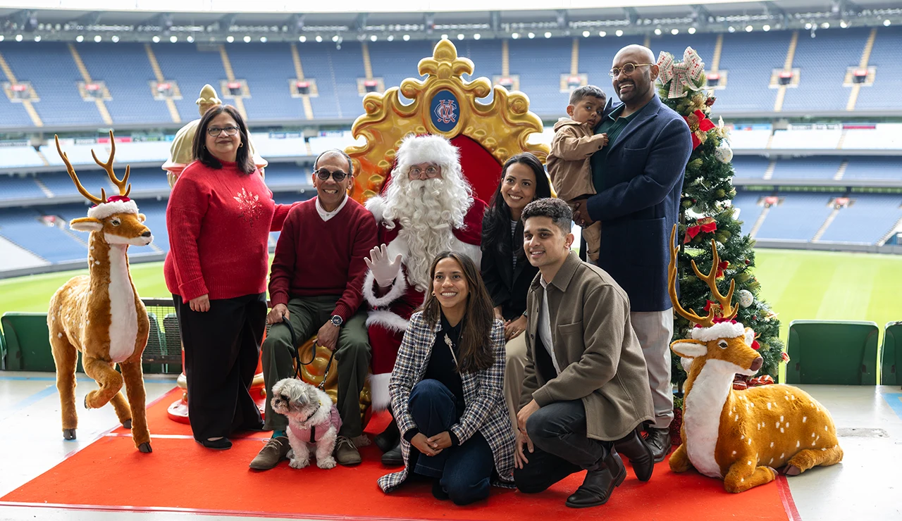 Family photo with Santa at the MCG with multiple generation and pet dog